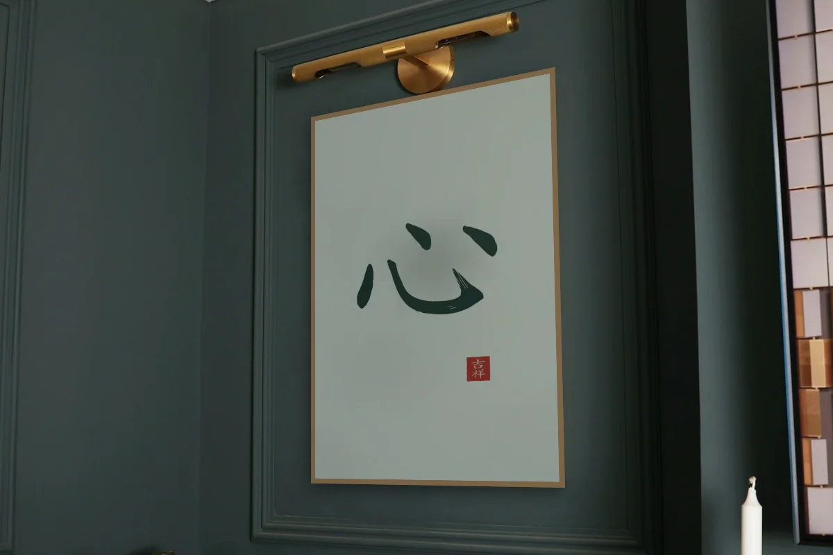 Cœur à l'encre, jade. Photo d'illustration : Affiche encadrée chêne sous une lampe de tableau, mur vert profond, œuvre en 60 × 90 cm, à l'échelle. Photo de la pièce : Paul Yarnell (Unsplash).