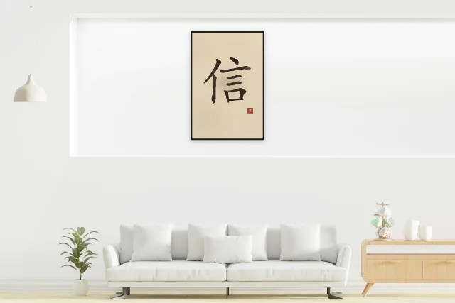 Confiance à l'encre, sable ocre : affiche encadrée noir dans la niche éclairée d'un salon blanc
