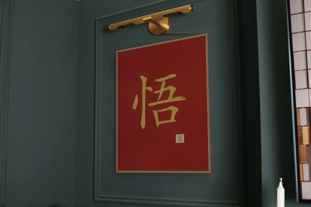 Éveil à l'encre, laque rouge : affiche encadrée chêne sous une lampe de tableau, mur vert profond