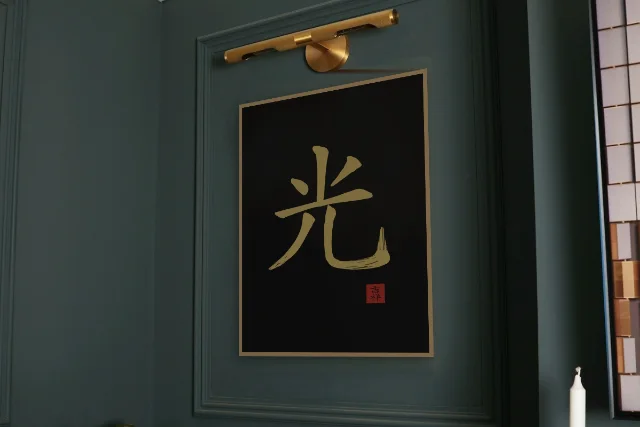 Lumière à l'encre, encre d’or : affiche encadrée chêne sous une lampe de tableau, mur vert profond