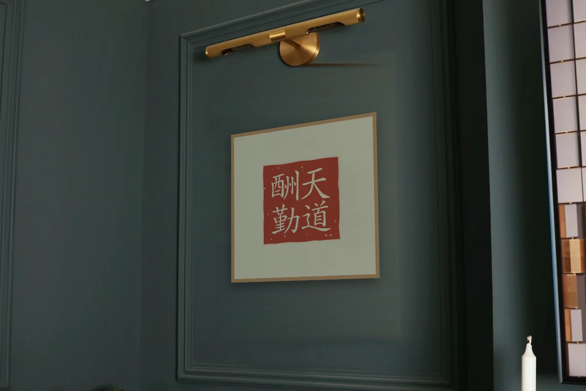 Le Ciel récompense l’effort en sceau, thé vert. Photo d'illustration : Affiche encadrée chêne sous une lampe de tableau, mur vert profond, œuvre en 50 × 50 cm, à l'échelle. Photo de la pièce : Paul Yarnell (Unsplash).