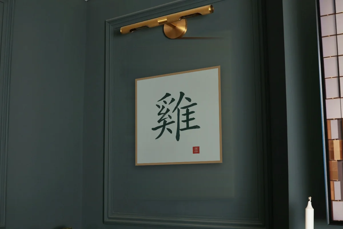 Signe du Coq à l'encre, jade. Photo d'illustration : Affiche encadrée chêne sous une lampe de tableau, mur vert profond, œuvre en 50 × 50 cm, à l'échelle. Photo de la pièce : Paul Yarnell (Unsplash).