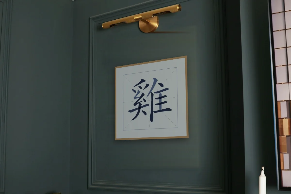 Signe du Coq en aplats, indigo. Photo d'illustration : Affiche encadrée chêne sous une lampe de tableau, mur vert profond, œuvre en 50 × 50 cm, à l'échelle. Photo de la pièce : Paul Yarnell (Unsplash).
