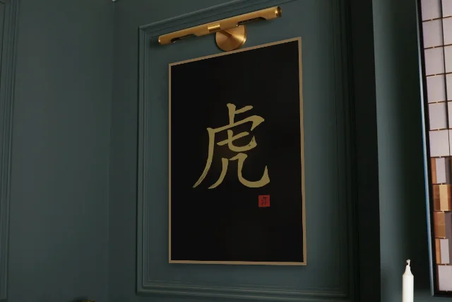Signe du Tigre à l'encre, encre d’or : affiche encadrée chêne sous une lampe de tableau, mur vert profond